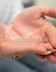 Closeup of patient holding clear aligner