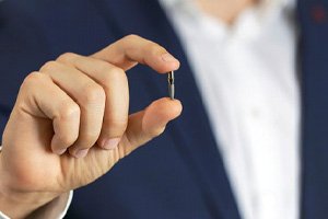 Man in business clothes holding dental implant