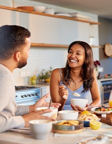 Couple smiling while enjoying meal at home