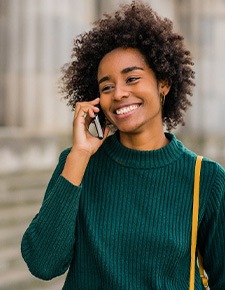 Woman smiling while talking on phone outside
