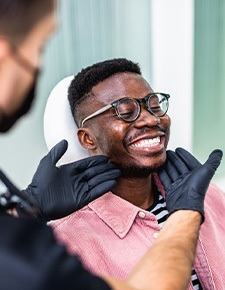 Dentist looking at smiling's patients teeth