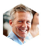 Man in blue shirt smiling after full mouth reconstruction