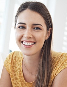 Young woman smiling after dental checkups and teeth cleanings
