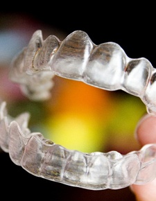 Hand holding Invisalign clear aligners