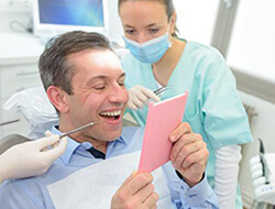 Man admiring his new dental implants in Friendswood