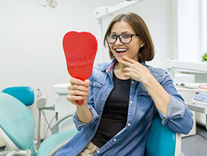 young woman admiring her new dental implants in Friendswood