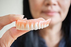 Woman holding a full denture