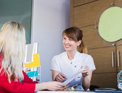 Patient and receptionist discussing how to pay for dental implants in Friendswood