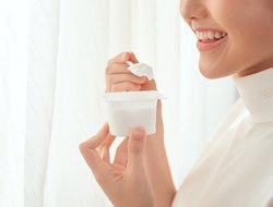 woman eating plain yogurt after dental implant surgery
