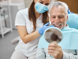 man smiling after getting dental implants in Friendswood