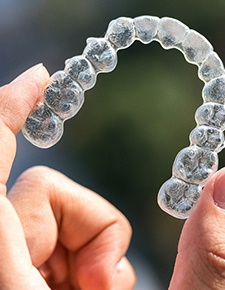 Hand holding aligner for Invisalign in Friendswood, TX