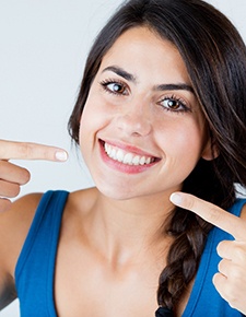 Woman pointing to her beautiful smile