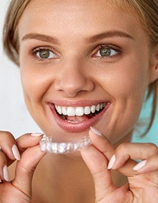 Woman holding Invisalign aligner