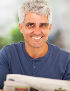 Man with a newspaper waking rested after Night Lase treatment