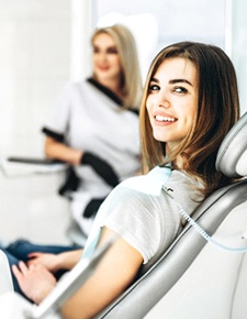 Female dental patient smiling at camera after restorative treatment