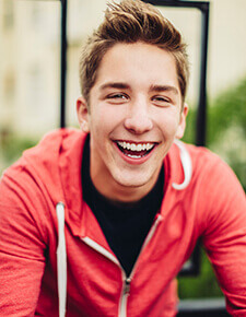 Young man smiling happily after orthodontic treatment