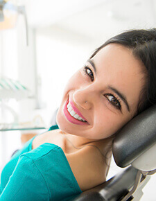 Woman smiling in dental chair during preventive dentistry treatment