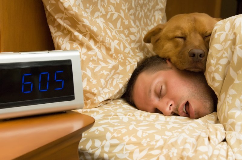 a man and his dog asleep in bed