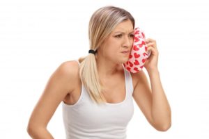 woman applying cold compress to face