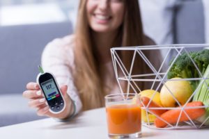 woman showing blood glucose monitor