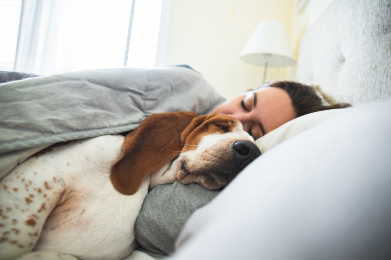 woman sleeping with dog