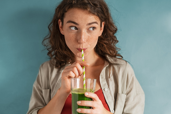 woman drinking green smoothie