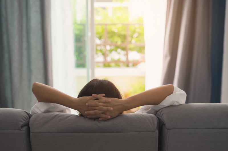 Woman resting on couch after All-on-4 surgery