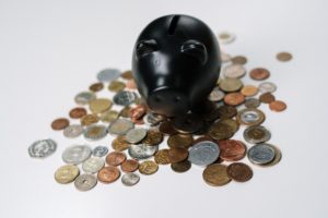 Black piggy bank on pile of coins