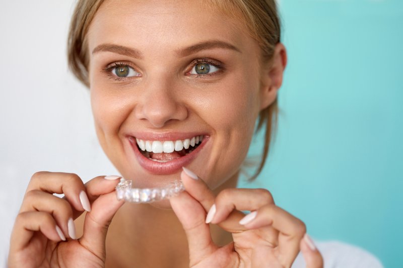 Woman smiling with her Invisalign aligner
