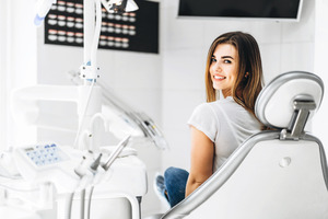 Woman with blonde hair sitting in dental chair smiling